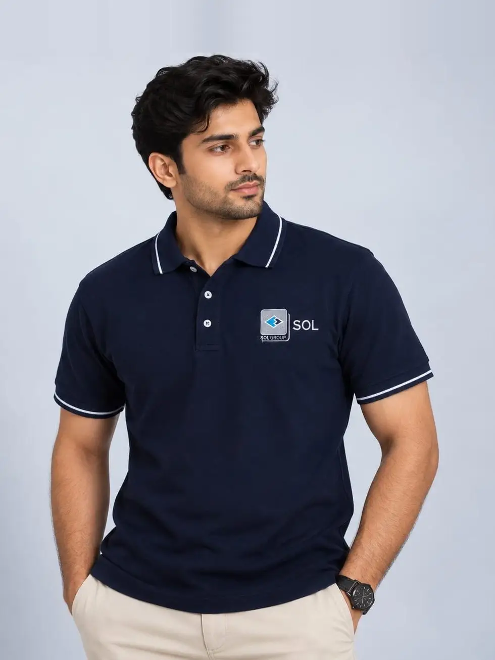 A model in a navy SOL corporate polo with white-tipped collar and cuffs, the company logo embroidered at the chest.